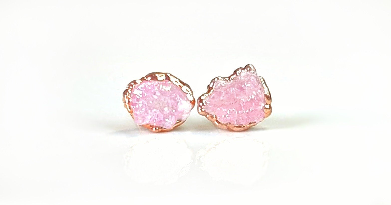 Raw rose quartz stud earrings set in rose gold, promoting self-love and happiness with a gentle energy.