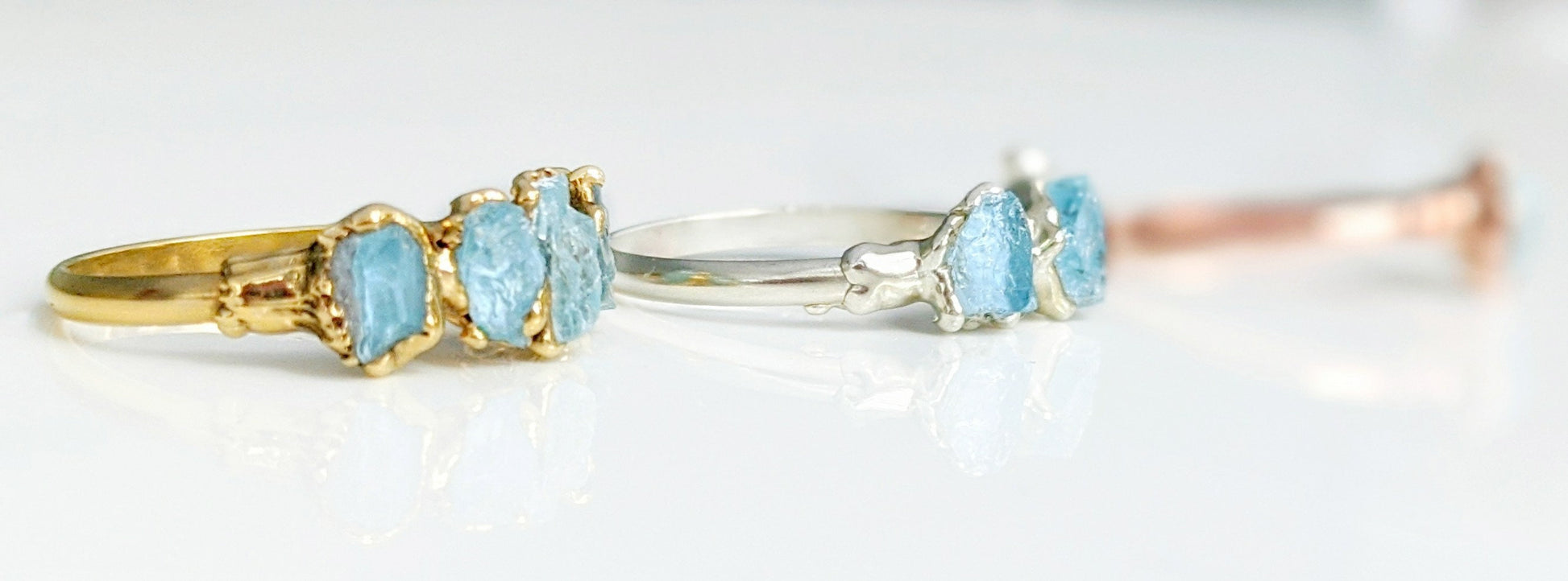 Raw Aquamarine eternity rings in gold and silver settings, showcasing natural gemstones with a rustic elegance.
