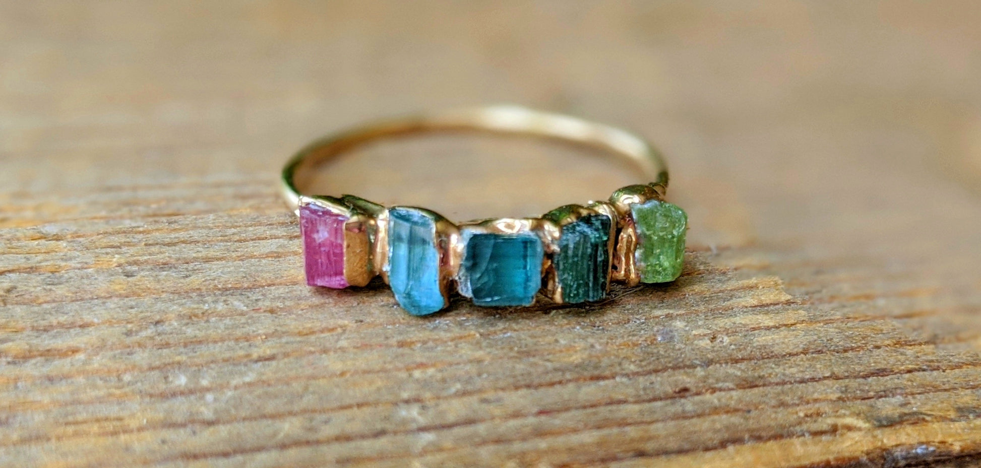 Elegant Raw Tourmaline eternity ring featuring five colorful stones on a gold-filled band.