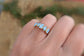 Raw aquamarine ring on a hand, featuring five small stones set on a 14k gold filled band, perfect for March birthdays.