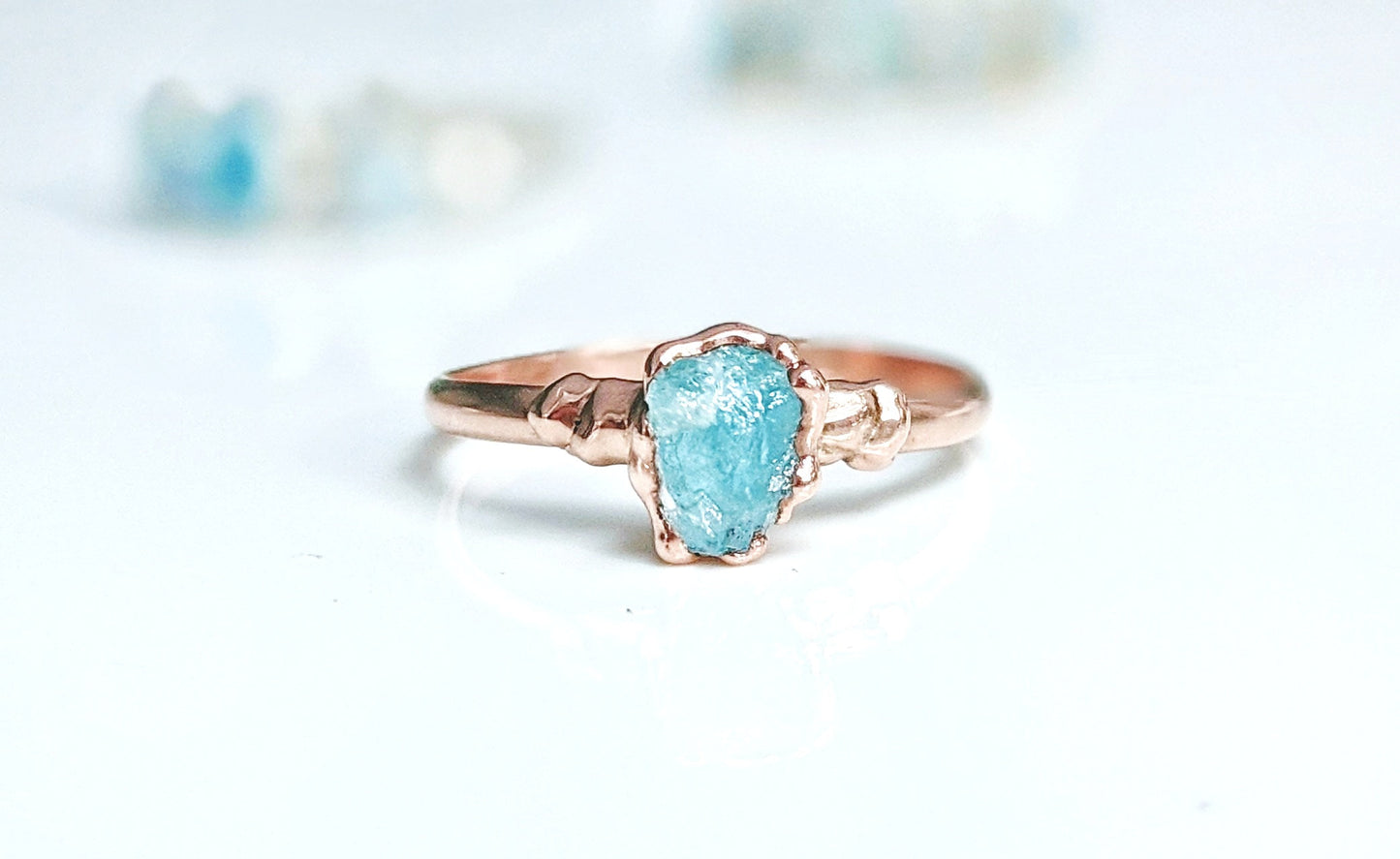Raw Aquamarine ring on a rose gold band, featuring a unique electroformed design. Perfect for March birthdays.