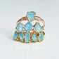 Raw Aquamarine rings in gold and rose gold, showcasing natural gemstones on a minimalist display.