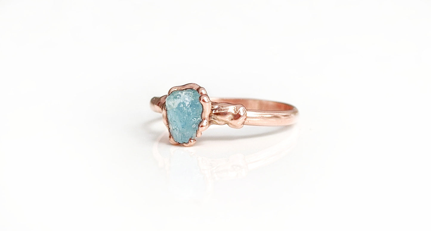 Raw Aquamarine Eternity ring on a rose gold band, showcasing rustic charm and natural beauty.