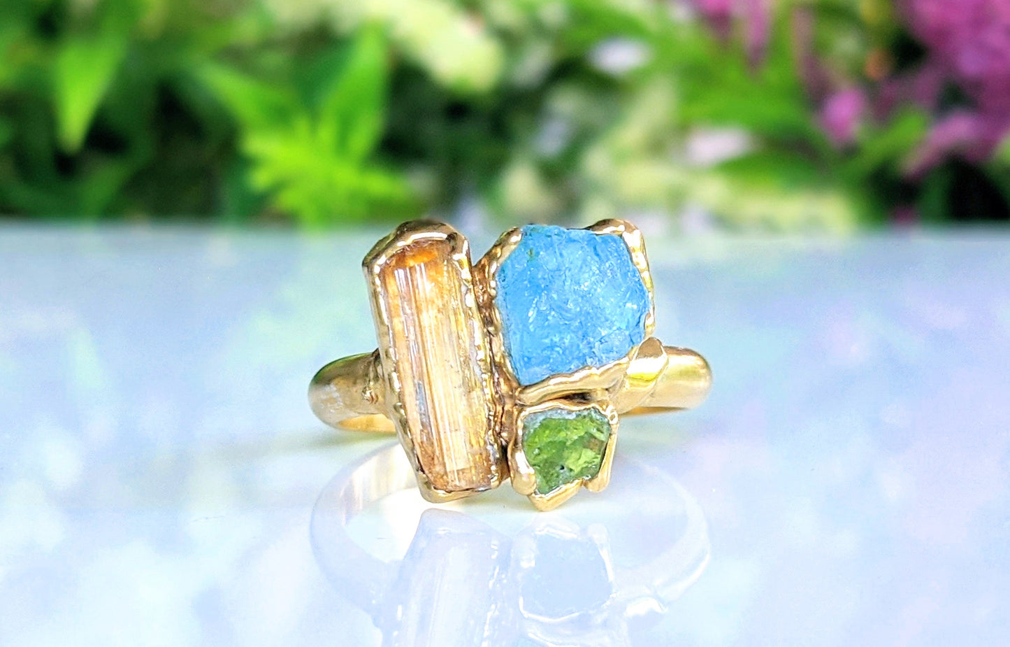 Raw Topaz, Aquamarine, and Peridot cluster ring on a gold band, perfect for summer outfits.