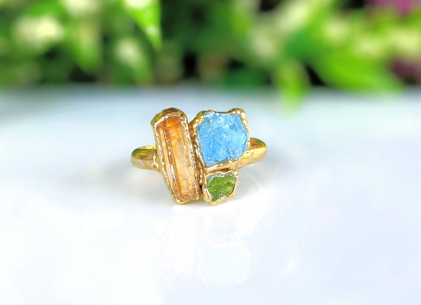 Raw Tourmaline multi-stone cluster ring featuring blue, pink, and green tourmaline on a gold band.