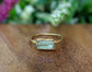 Raw yellow Apatite ring with 14k gold filled band, set on a wooden surface surrounded by greenery.