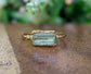 Raw yellow Apatite ring with 14k gold filled band, 8-12mm, displayed on wooden surface.