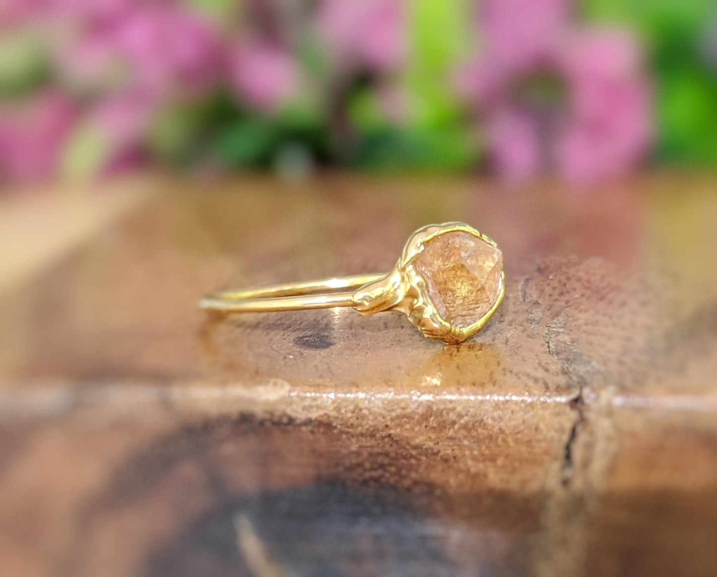 Raw Hessonite Garnet ring on a gold band, showcasing a natural gem with warm golden hues.
