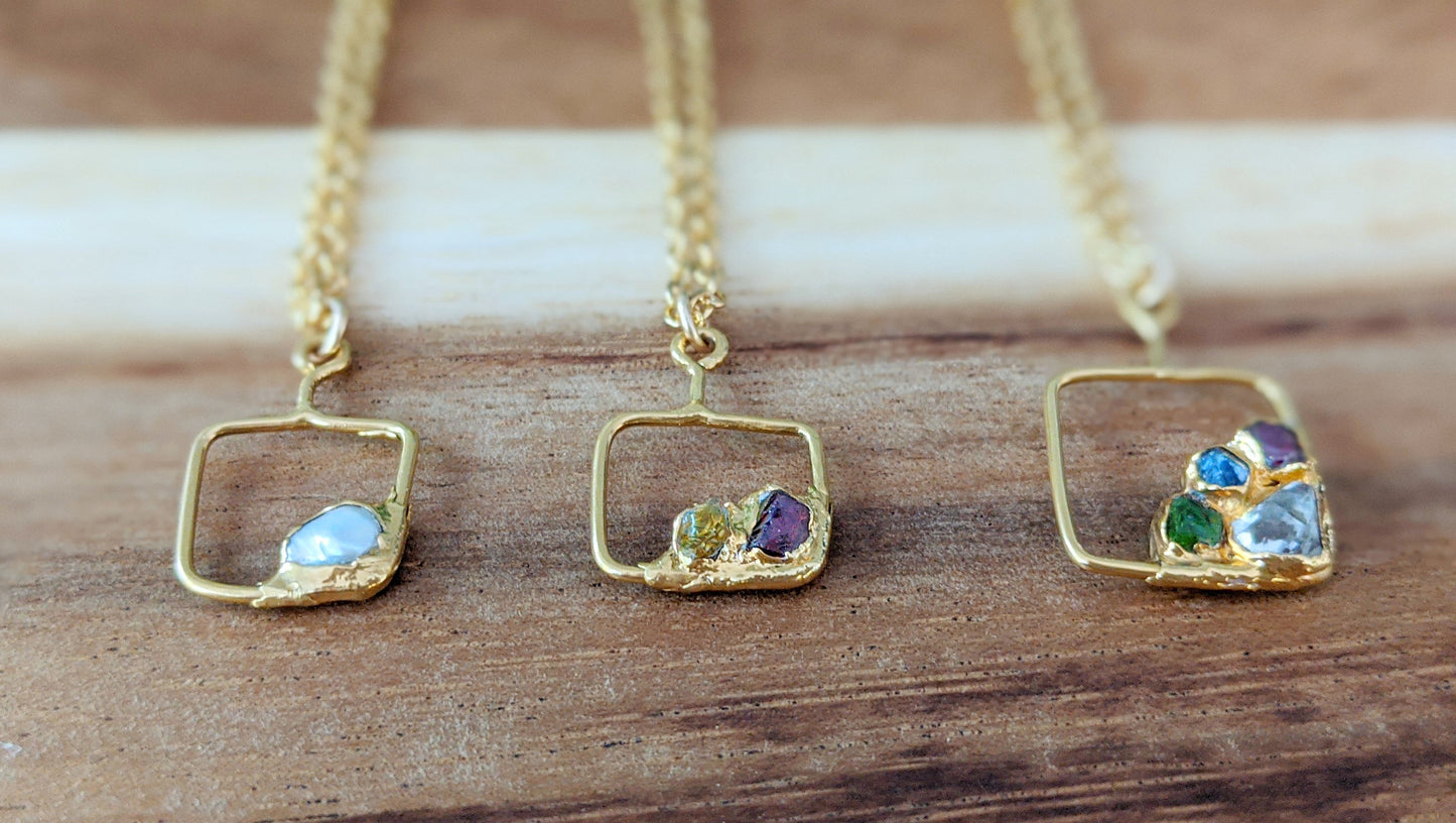 Three unique gold-filled family birthstone necklaces featuring raw gemstones in square pendants.