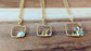 Three unique gold-filled family birthstone necklaces featuring raw gemstones in square pendants.