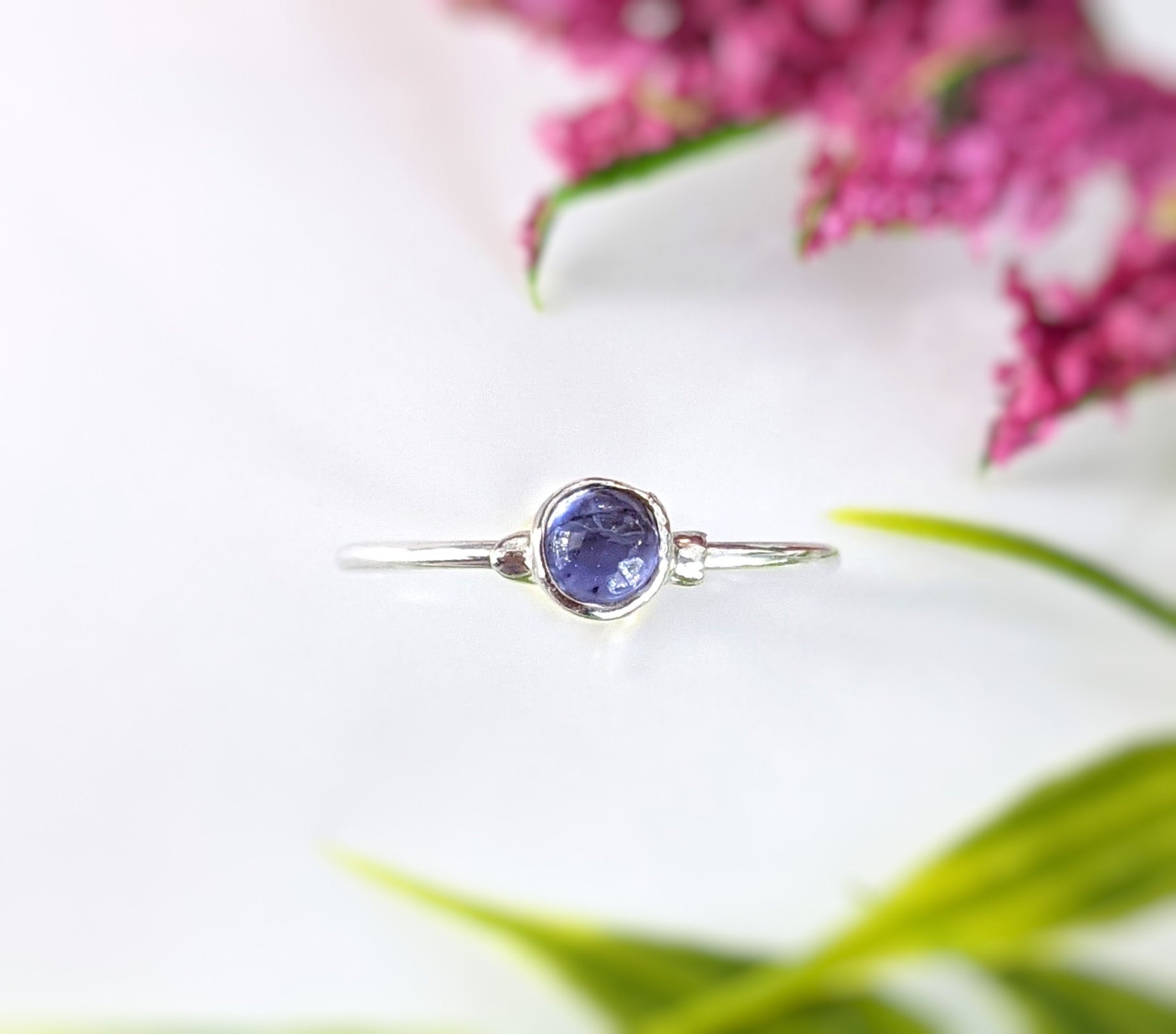 Minimalist dainty tanzanite stacking ring on a silver band with purple/blue gemstone, ideal for everyday wear.