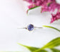 Minimalist dainty tanzanite stacking ring on a silver band with purple/blue gemstone, ideal for everyday wear.