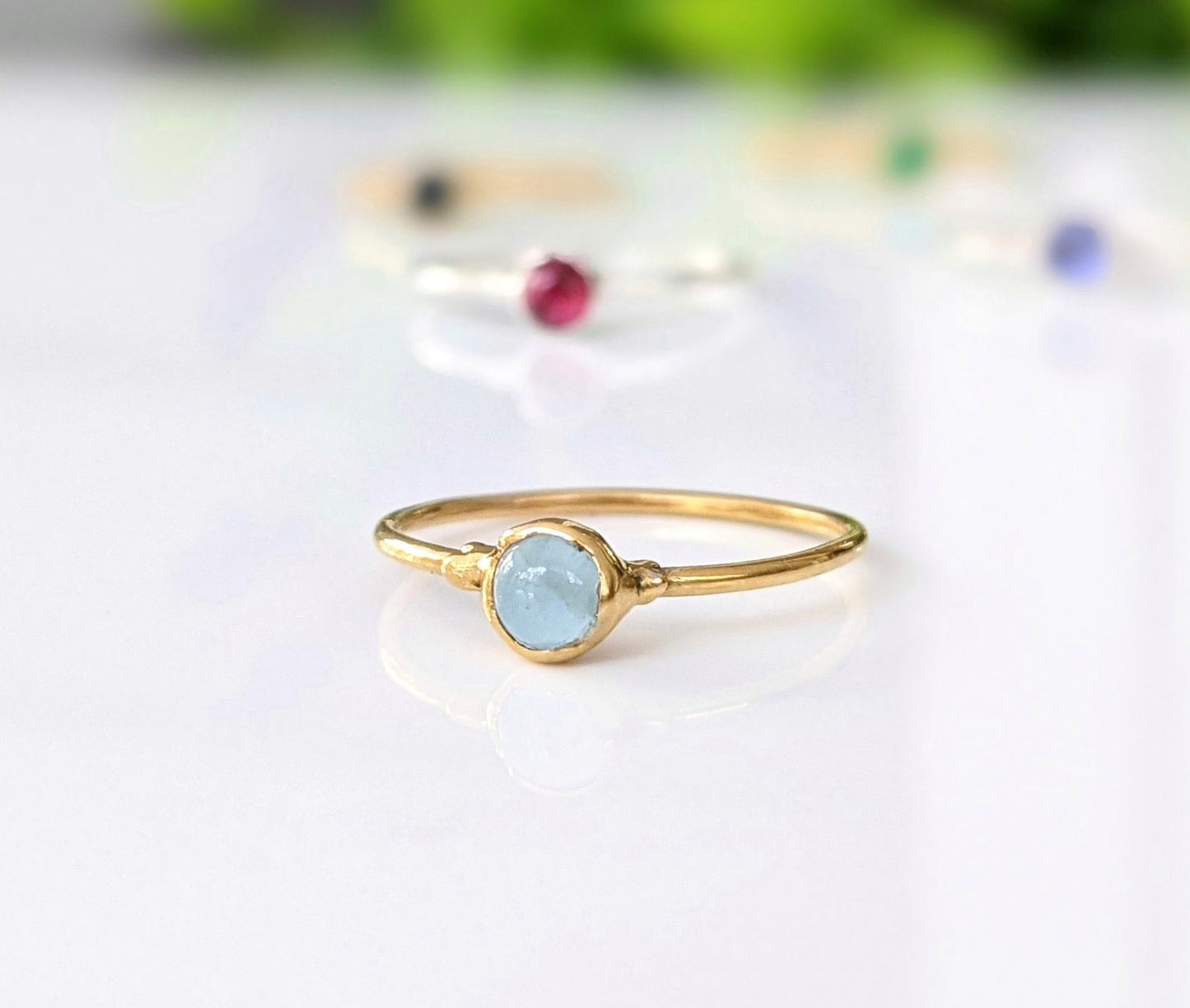 Dainty aquamarine stacking ring on a gold band, perfect for everyday wear or as a March birthstone ring.