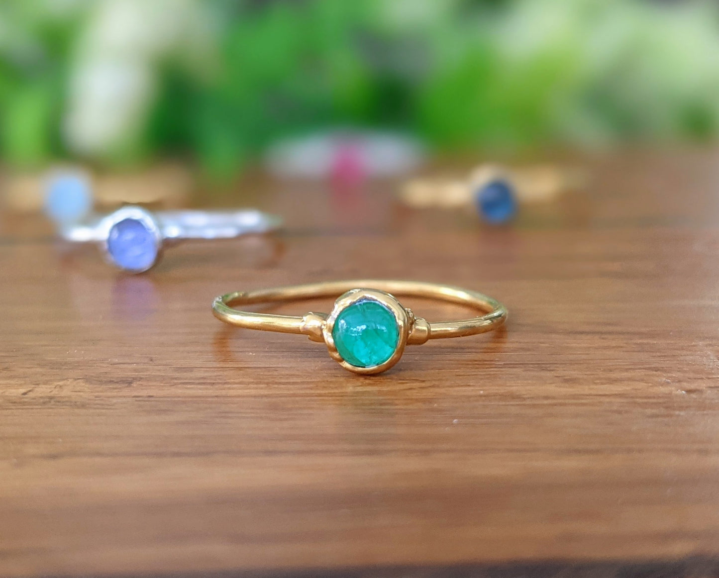 Dainty emerald stacking ring with a 4mm natural green emerald on a gold filled band, perfect for minimalist style.