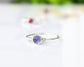 Dainty stacking ring featuring a 4mm natural purple-blue Tanzanite gemstone in a minimalist sterling silver band.