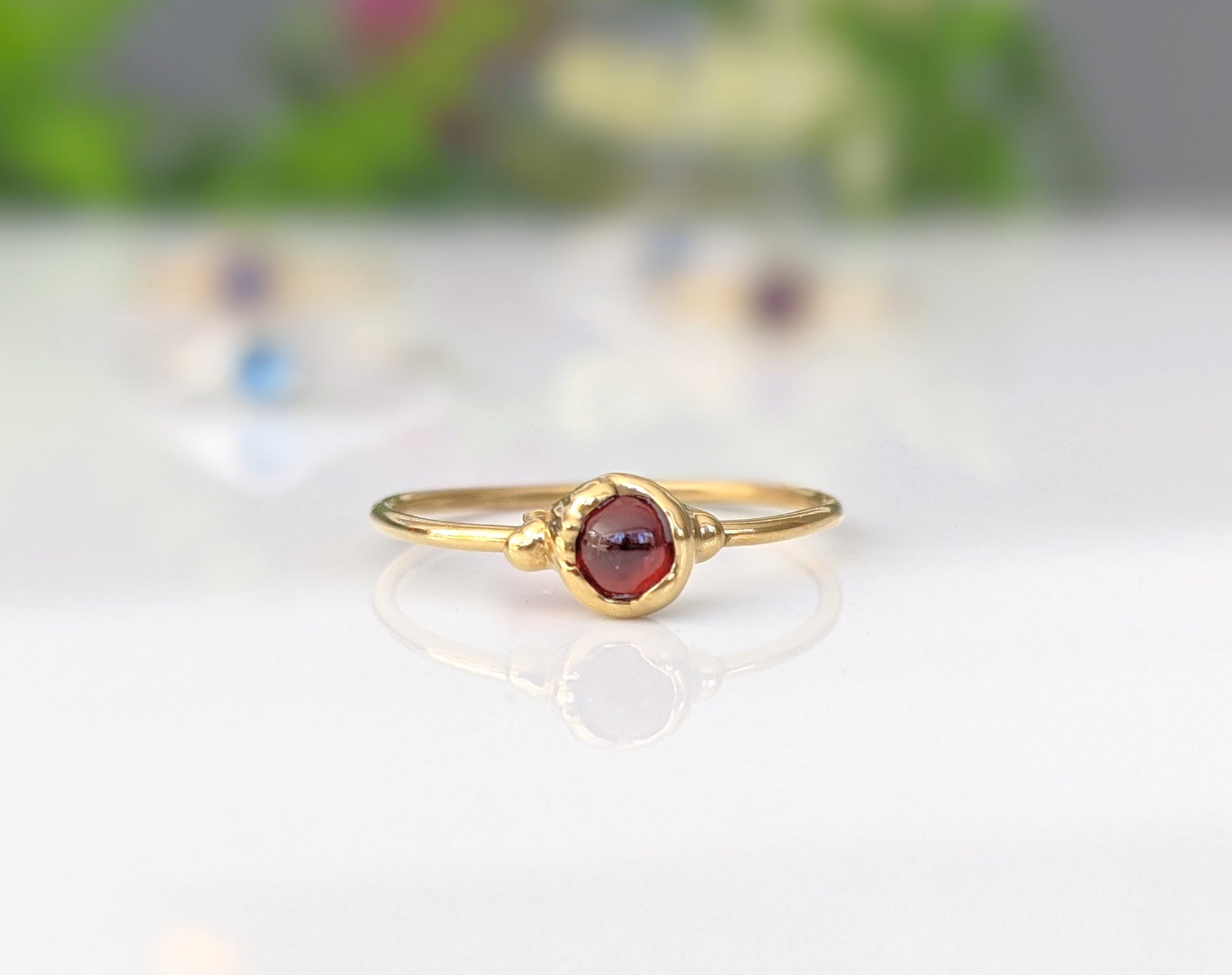 Dainty gold stacking ring featuring a natural red Garnet gemstone, perfect for minimalist jewelry lovers.