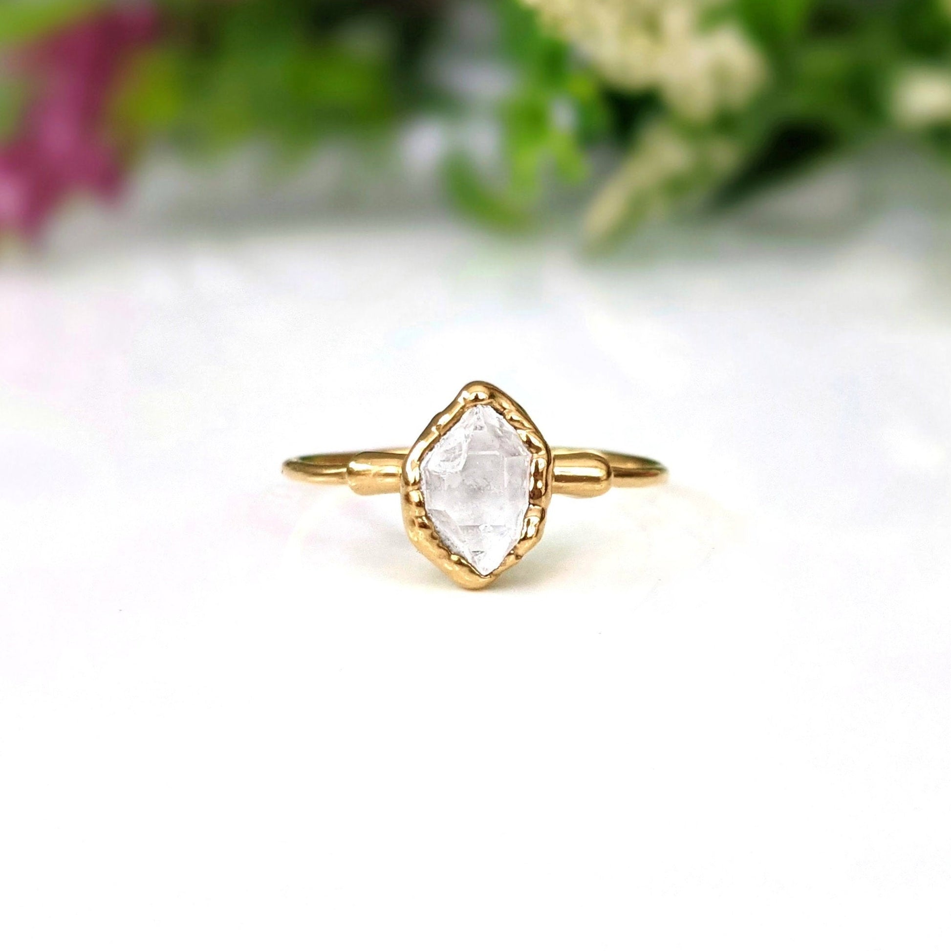 Herkimer diamond chevron engagement ring set on display, featuring a unique handcrafted design with a gold band.
