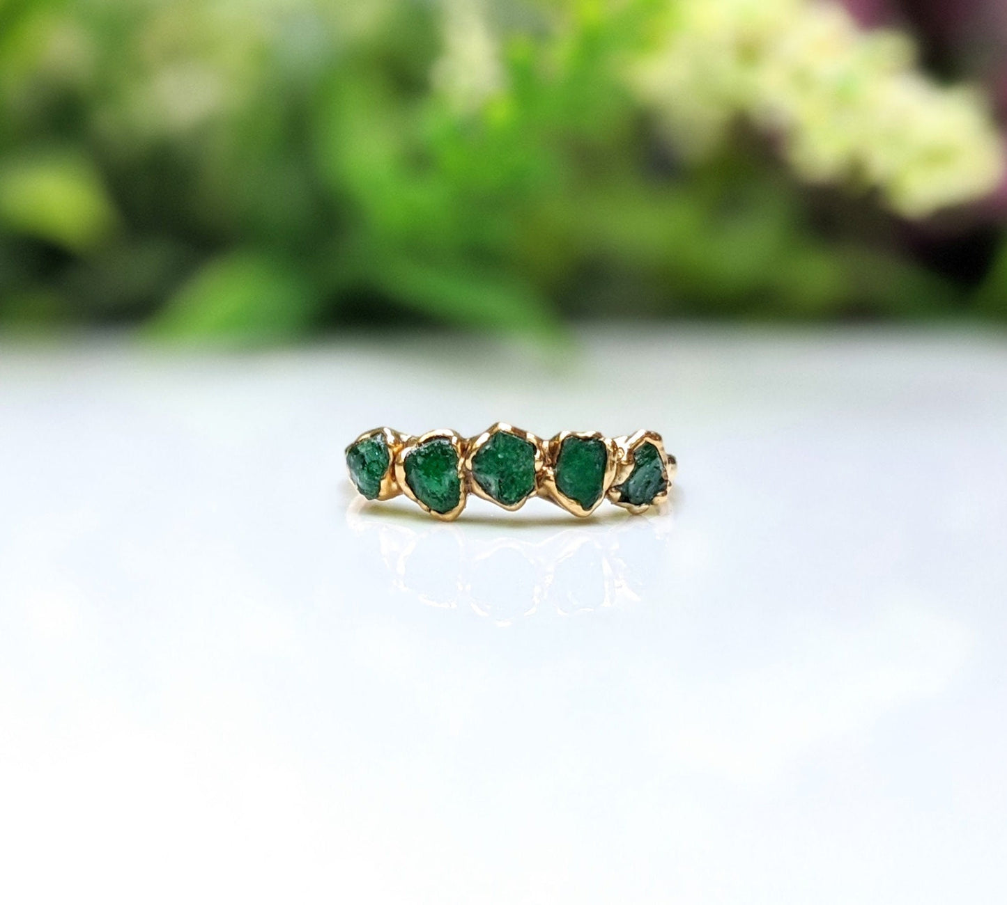 Raw emerald multi-stone ring on a gold band, featuring 5 small raw emeralds, ideal May birthstone jewelry.