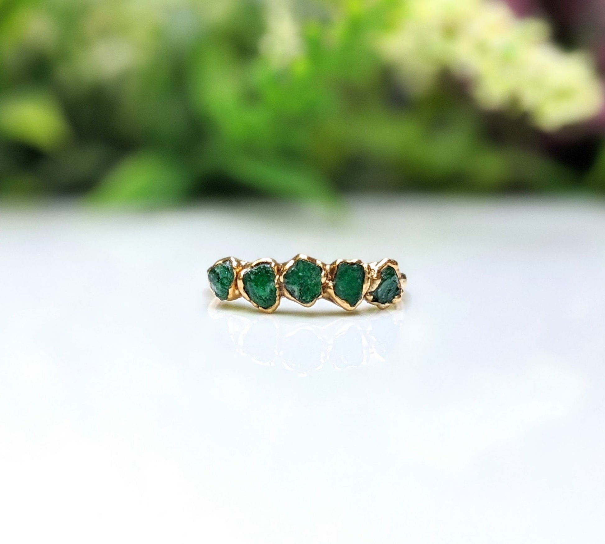 Raw emerald multi-stone ring on a gold band, featuring 5 small raw emeralds, ideal May birthstone jewelry.