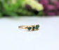 Raw Emerald multi-stone ring on a gold band, featuring 5-7 small raw emeralds, perfect May birthstone accessory.