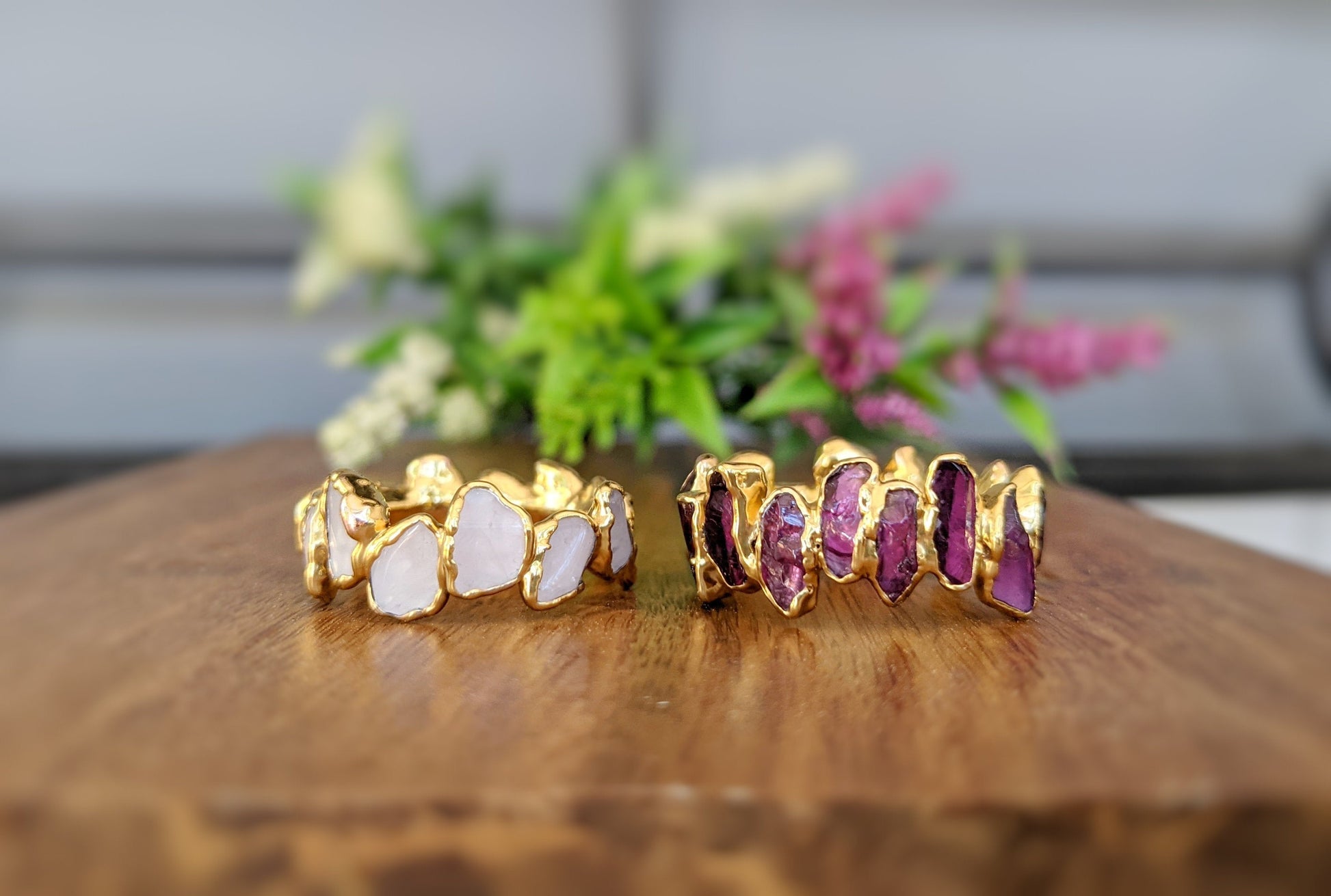 Elegant raw gemstone eternity rings in gold, featuring contrasting colors and shapes, perfect for a timeless jewelry collection.