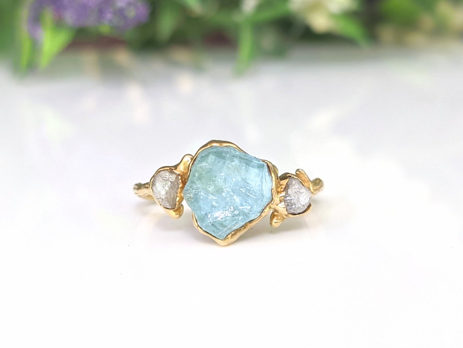 Raw Aquamarine and diamond twig ring featuring a unique gold band, perfect for engagement or promise ring.