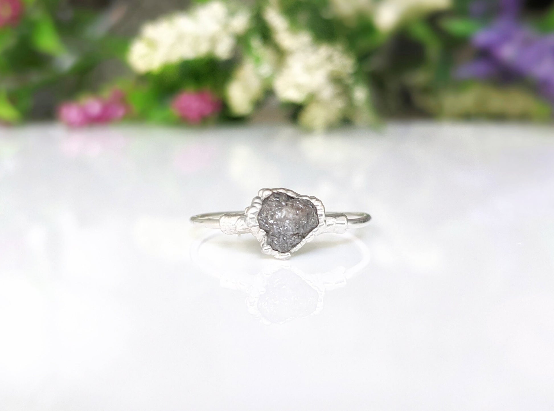 Handcrafted raw uncut grey diamond engagement ring on a sterling silver band with floral details.