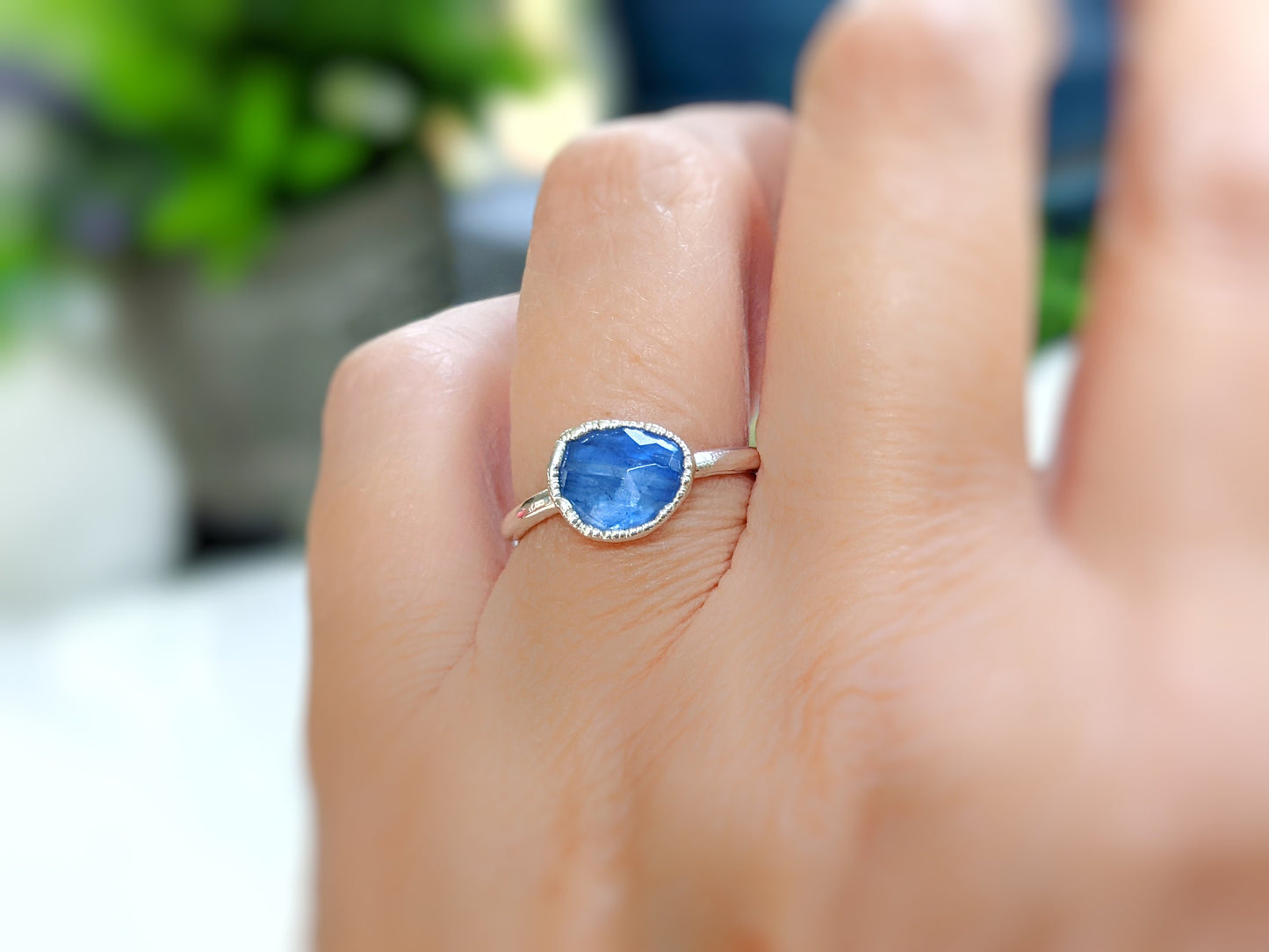Rustic blue Kyanite ring on a hand, set in a Sterling Silver band, perfect for nature lovers.