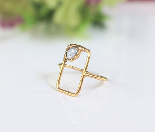 Handcrafted geometric ring featuring a freshwater Keshi pearl set in a solid 14k gold band.