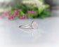 Raw Morganite ring with sterling silver band and rough diamond, showcasing natural pink gem and rustic elegance.