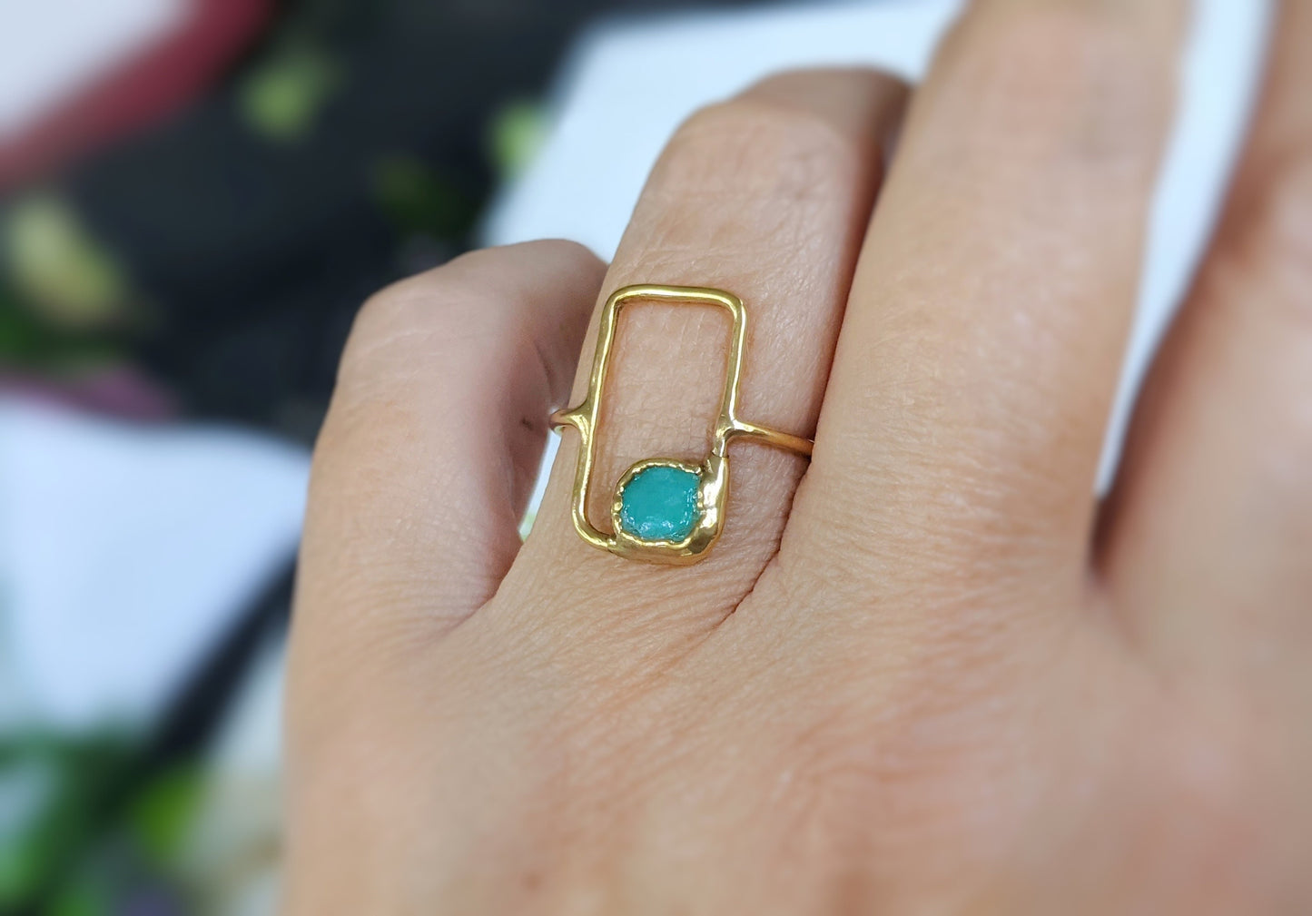 Dainty raw Peruvian opal geometric ring on a hand, featuring a blue opal and a 14k gold band.