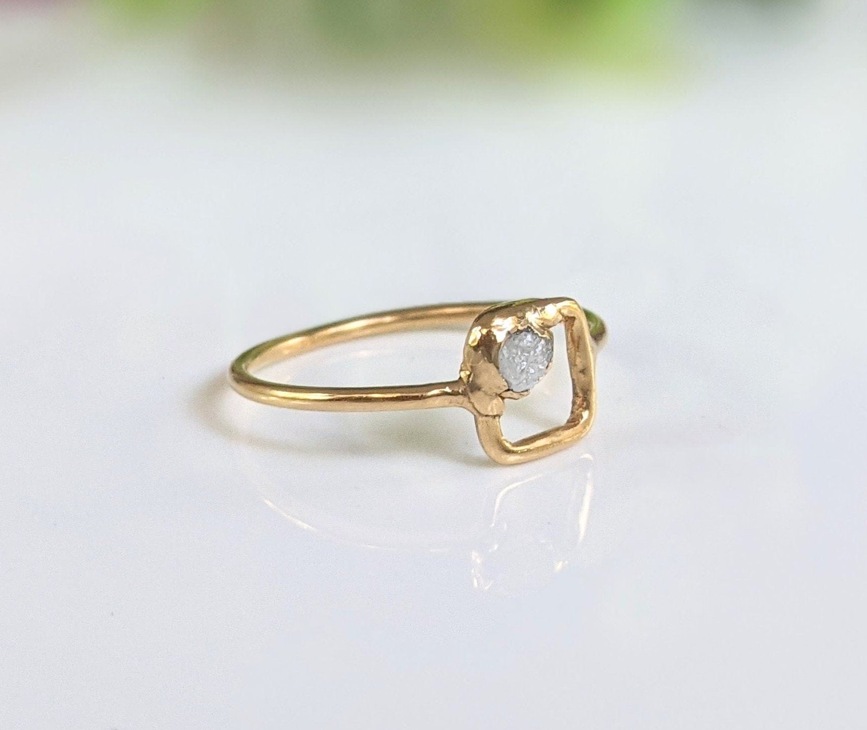 Minimalist Solid Gold square ring featuring a raw diamond set in a unique geometric band design.