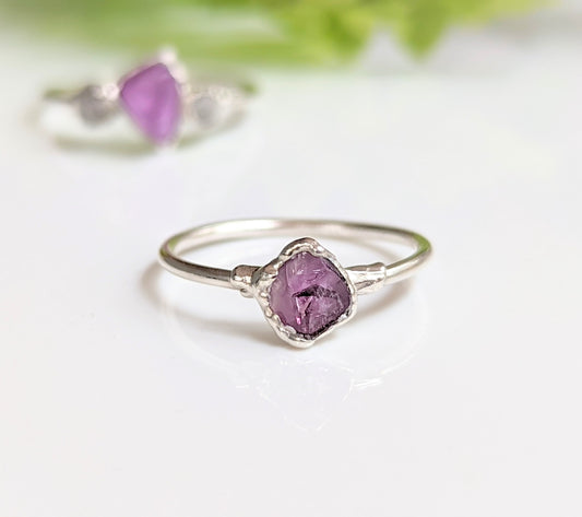 Raw Alexandrite silver ring on a white surface, featuring a unique lab-grown gemstone set in a delicate sterling silver band.