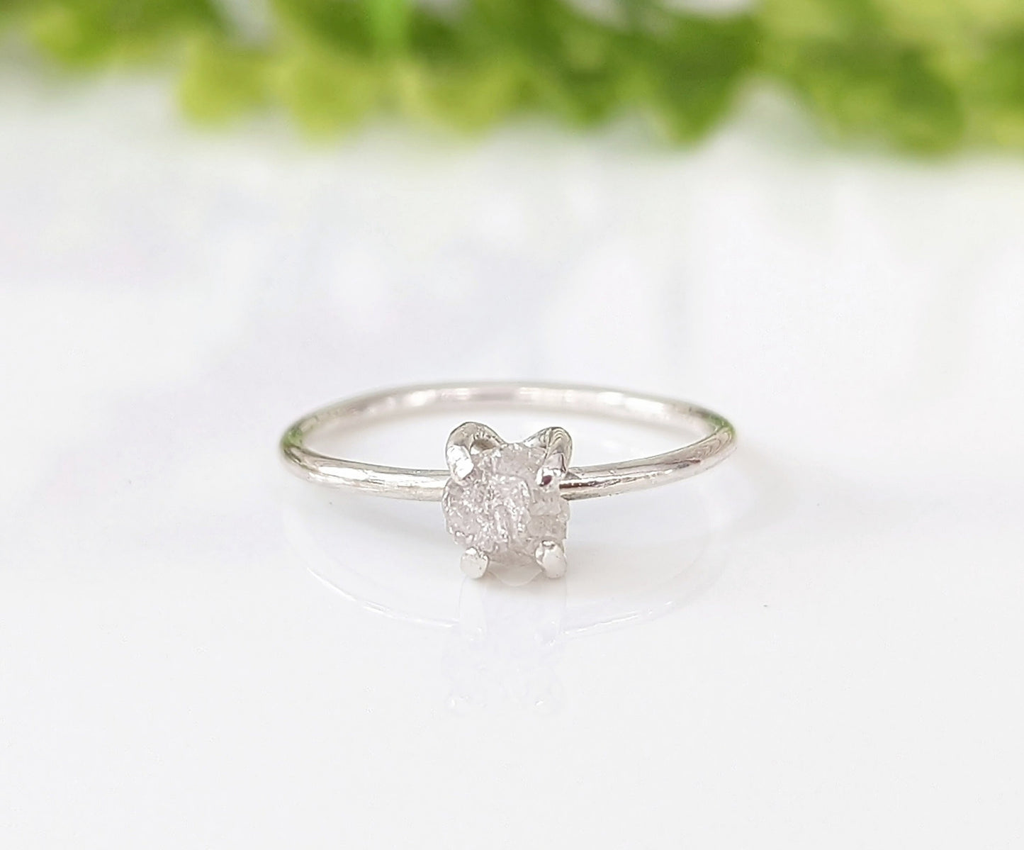 Delicate sterling silver raw diamond engagement ring with a unique prong setting and sparkling conflict-free diamond.