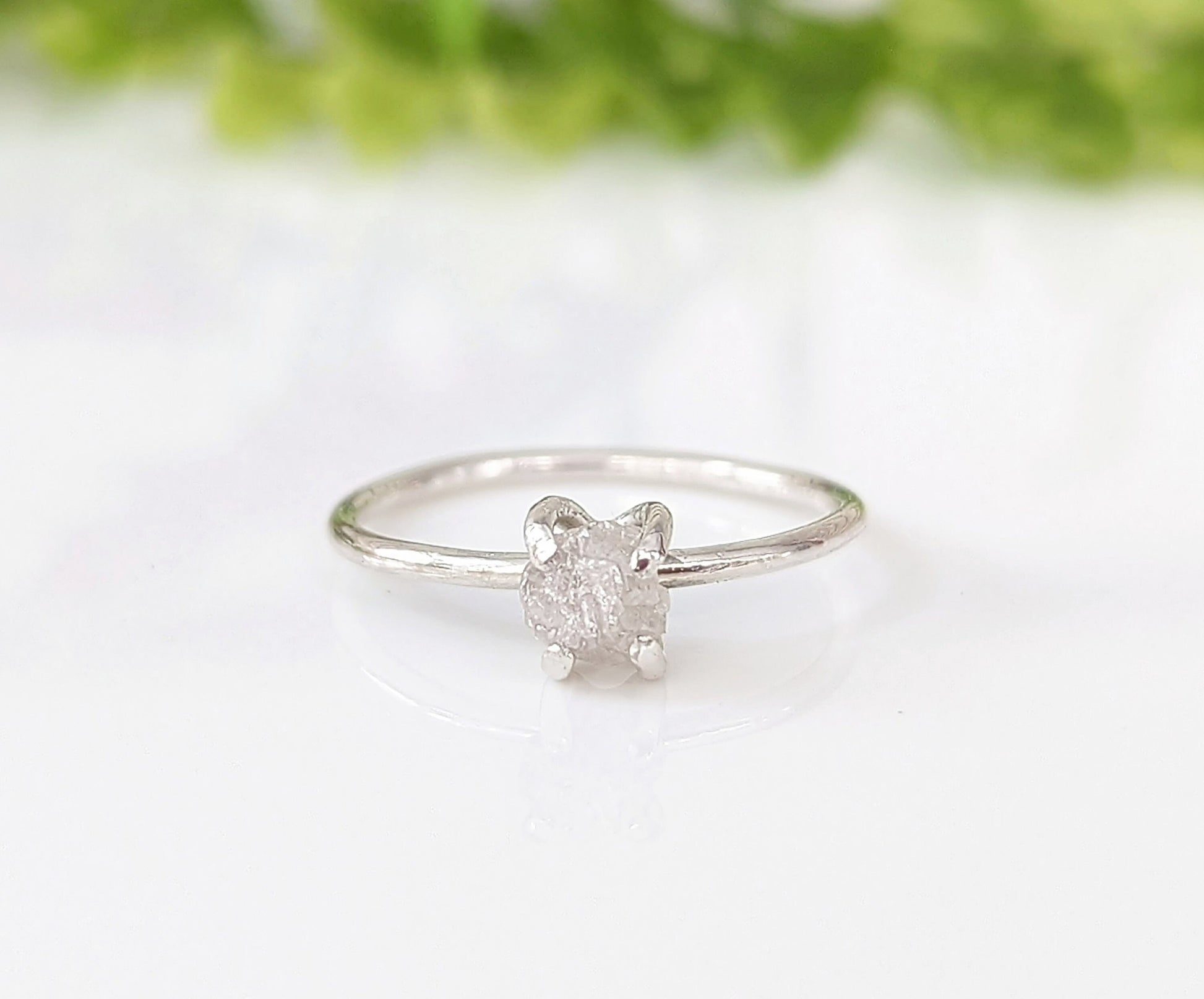Delicate sterling silver raw diamond engagement ring with a unique prong setting and sparkling conflict-free diamond.