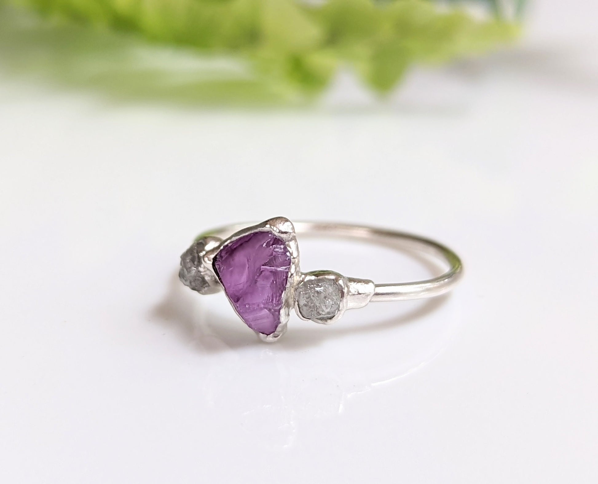 Handcrafted silver ring featuring raw Alexandrite and two ethically sourced diamonds.