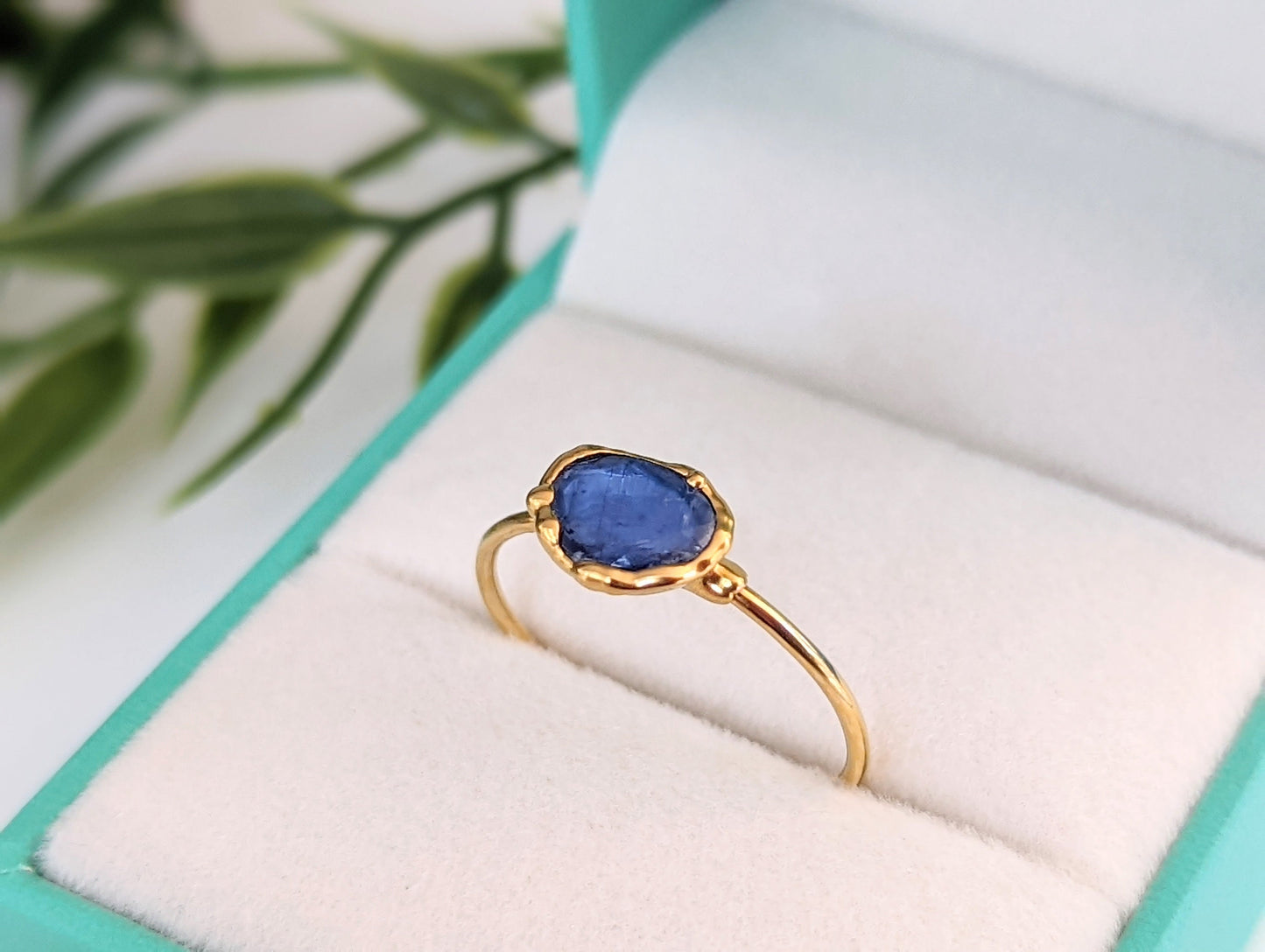 Blue Kyanite rose-cut stone set in a solid 14k gold band, presented in a plush ring box.
