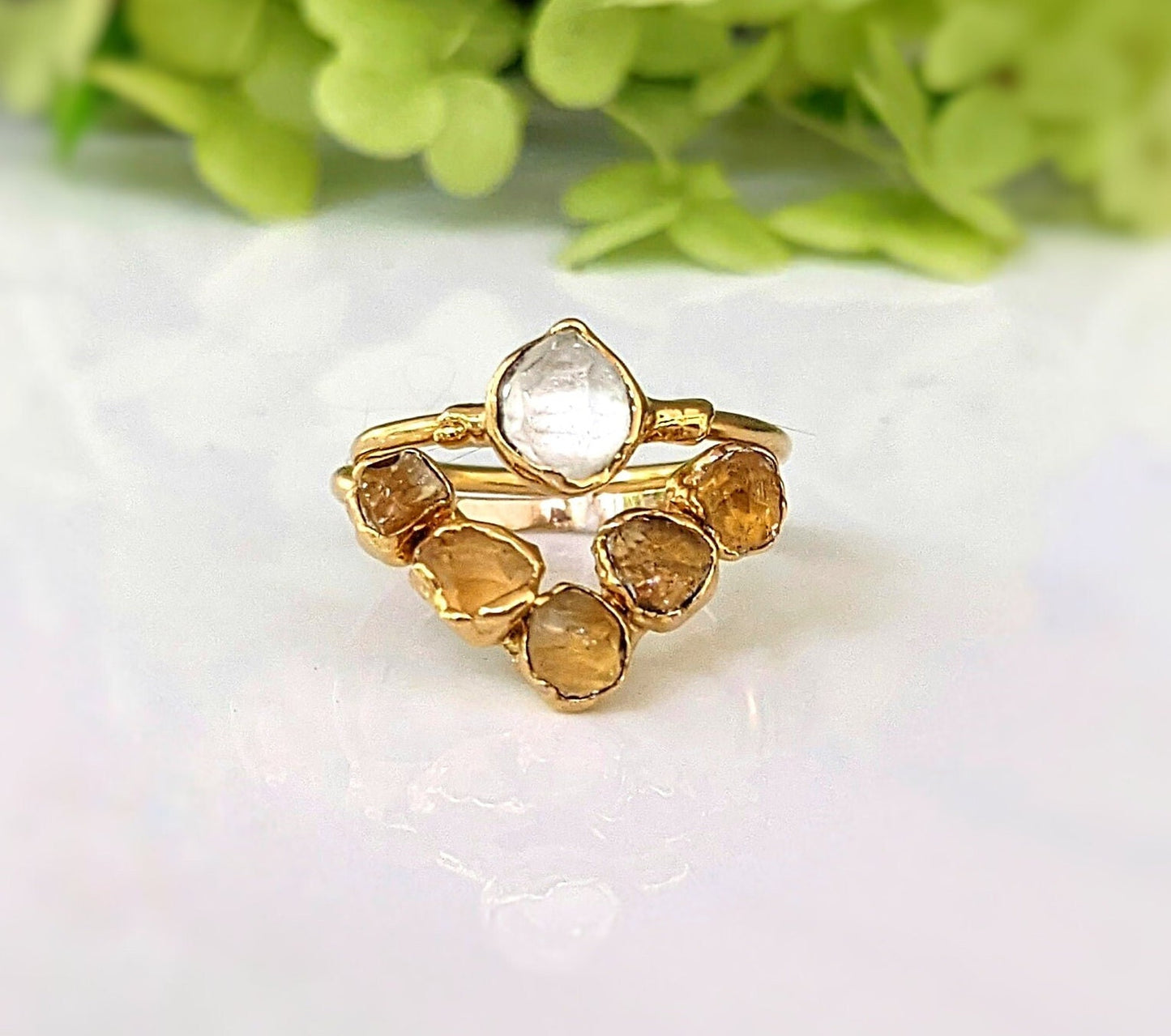 Raw Citrine and Herkimer diamond chevron engagement ring on display with delicate gold band.