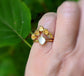 Raw Citrine and Herkimer diamond chevron engagement ring on a hand, featuring a 14k gold band.