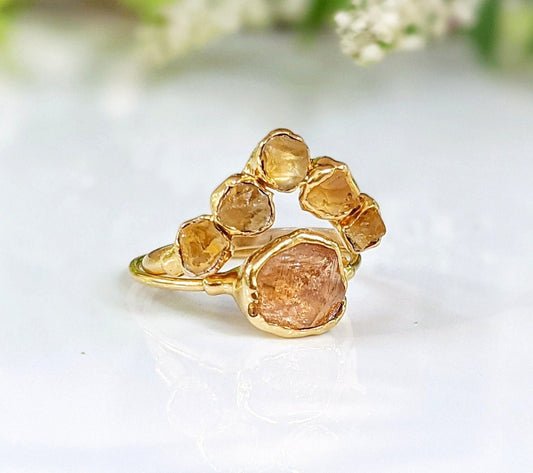 Raw Topaz and Citrine Chevron ring set on a white background, featuring golden gems in a unique design.