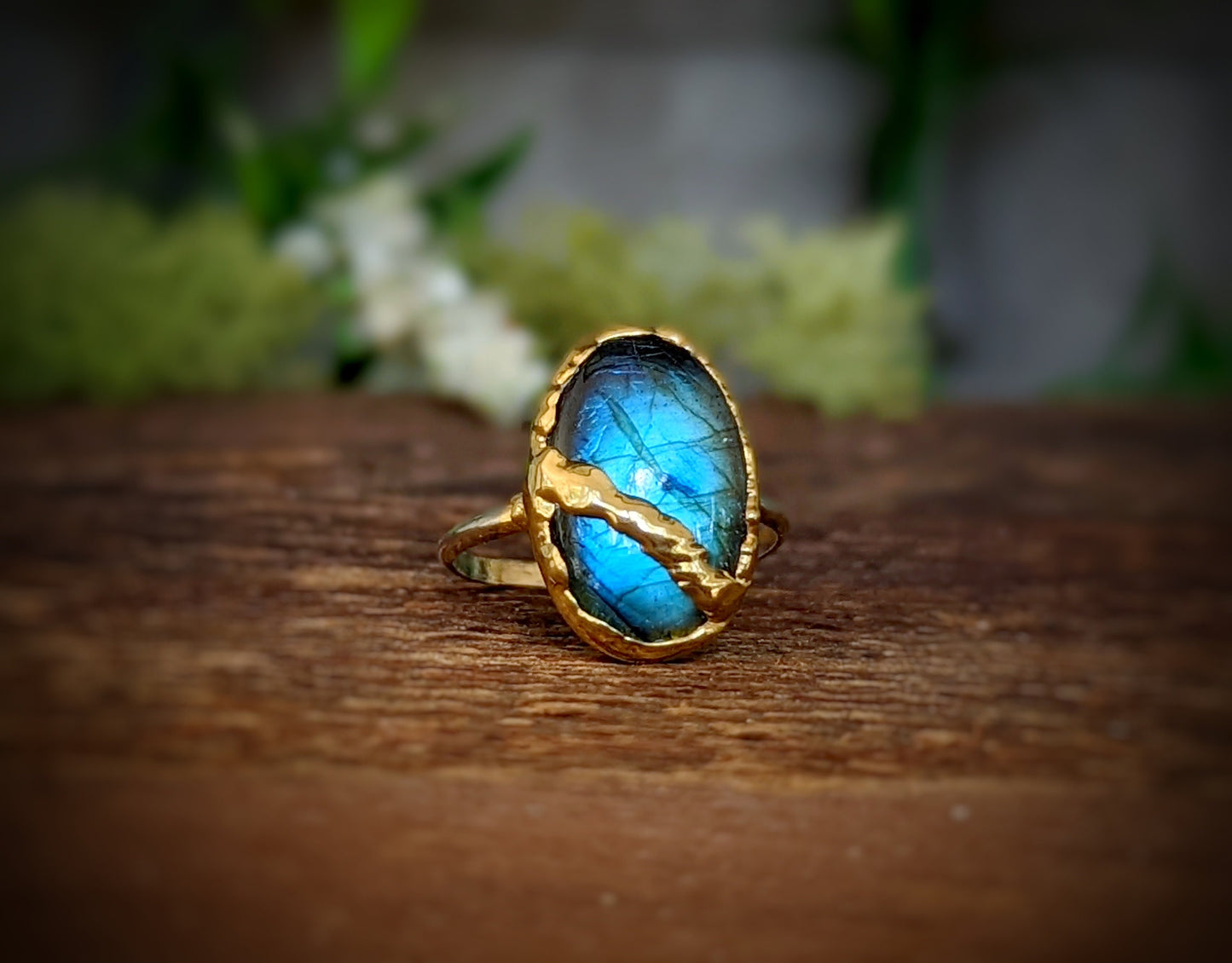 Labradorite Kintsugi ring featuring a blue stone set in a gold band, symbolizing beauty in restoration.