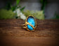 Labradorite Kintsugi ring featuring a blue stone set in a gold band, symbolizing beauty in restoration.
