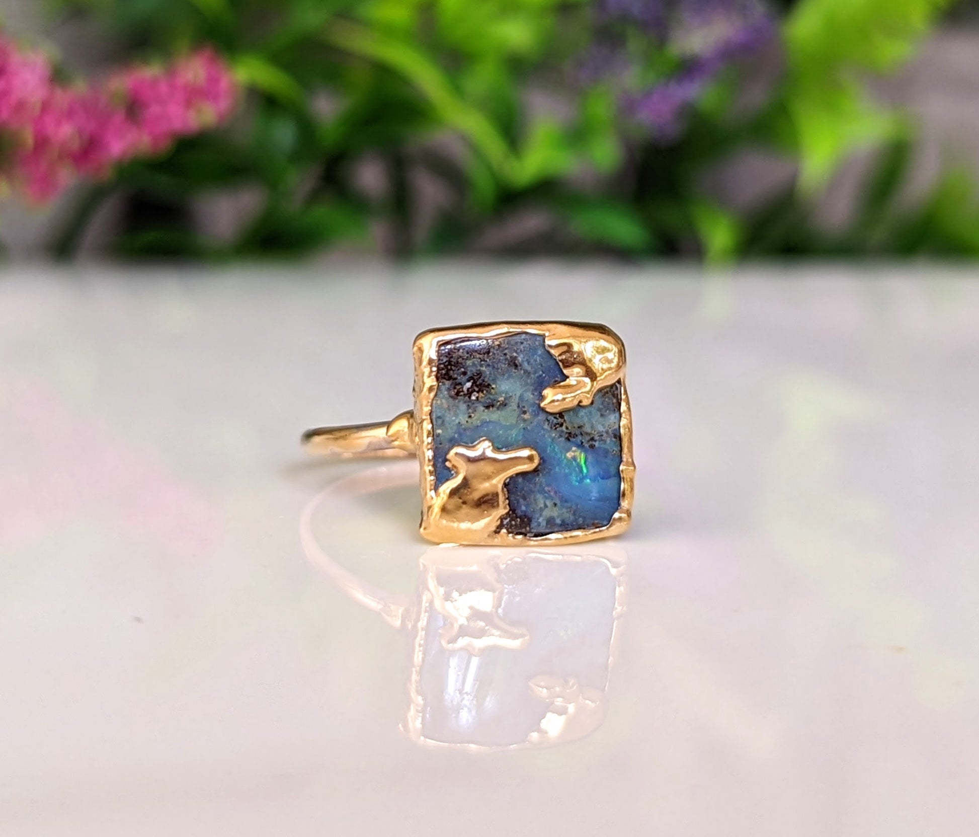 Australian Opal Kintsugi ring on a gold band, showcasing unique artistic imperfections and vibrant colors.