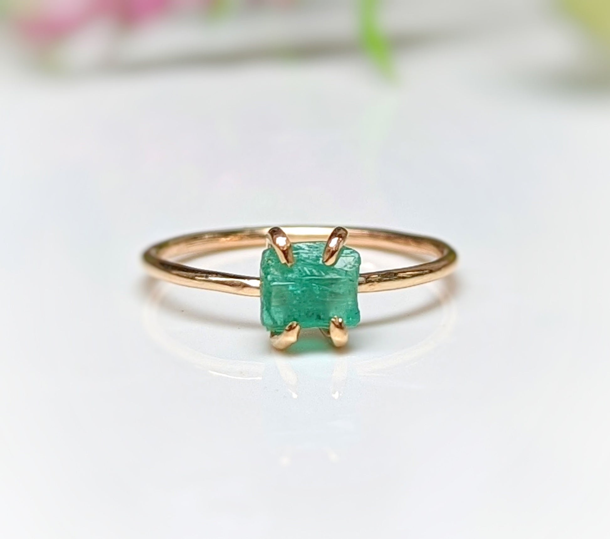 Raw emerald solitaire ring set in solid 14k gold, perfect for unique gifts and engagement celebrations.