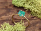 Raw emerald solitaire ring in solid 14k gold, showcasing a unique green gemstone on a rustic gold band.