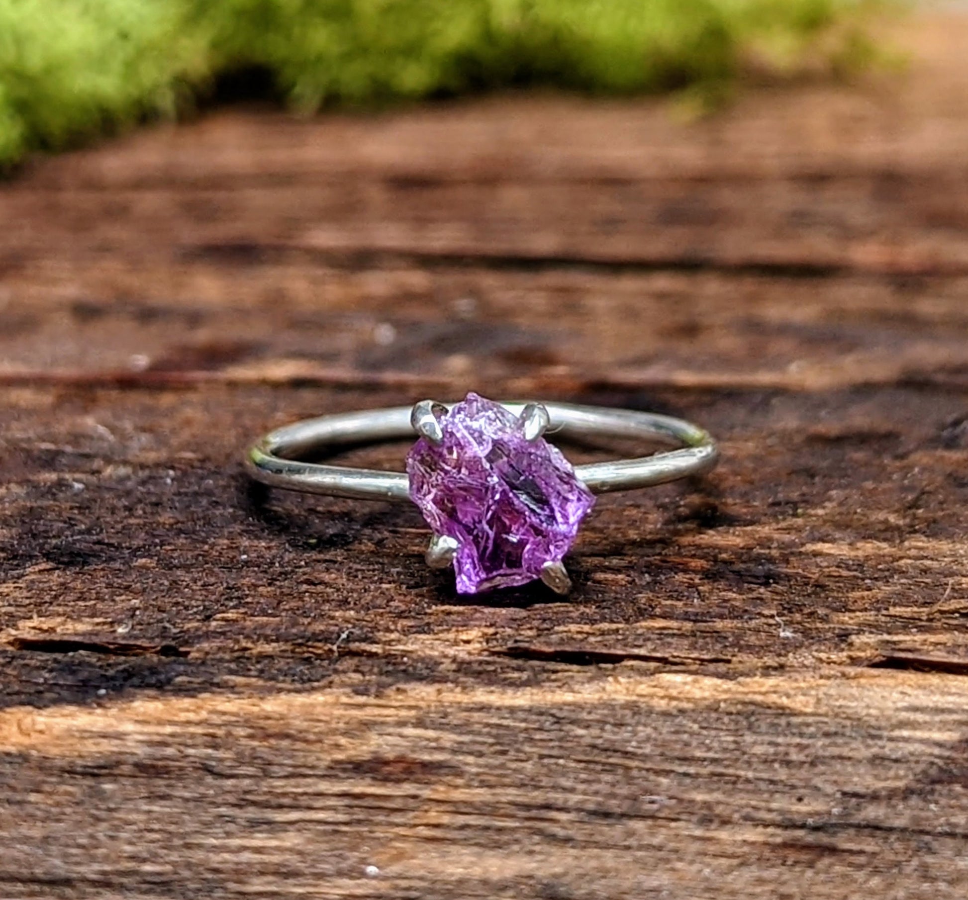 Raw Alexandrite engagement ring in sterling silver, showcasing a unique 7-9mm stone on a rustic wooden surface.