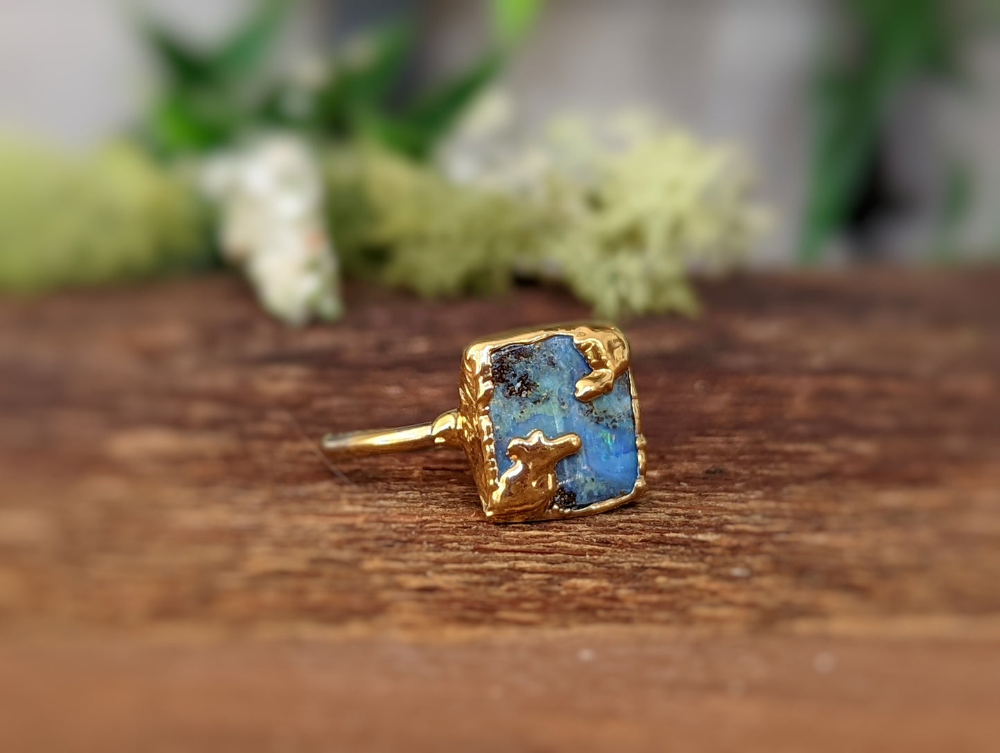 Australian Opal Kintsugi ring with gold electroforming on a natural wood background, showcasing uniqueness and artistry.