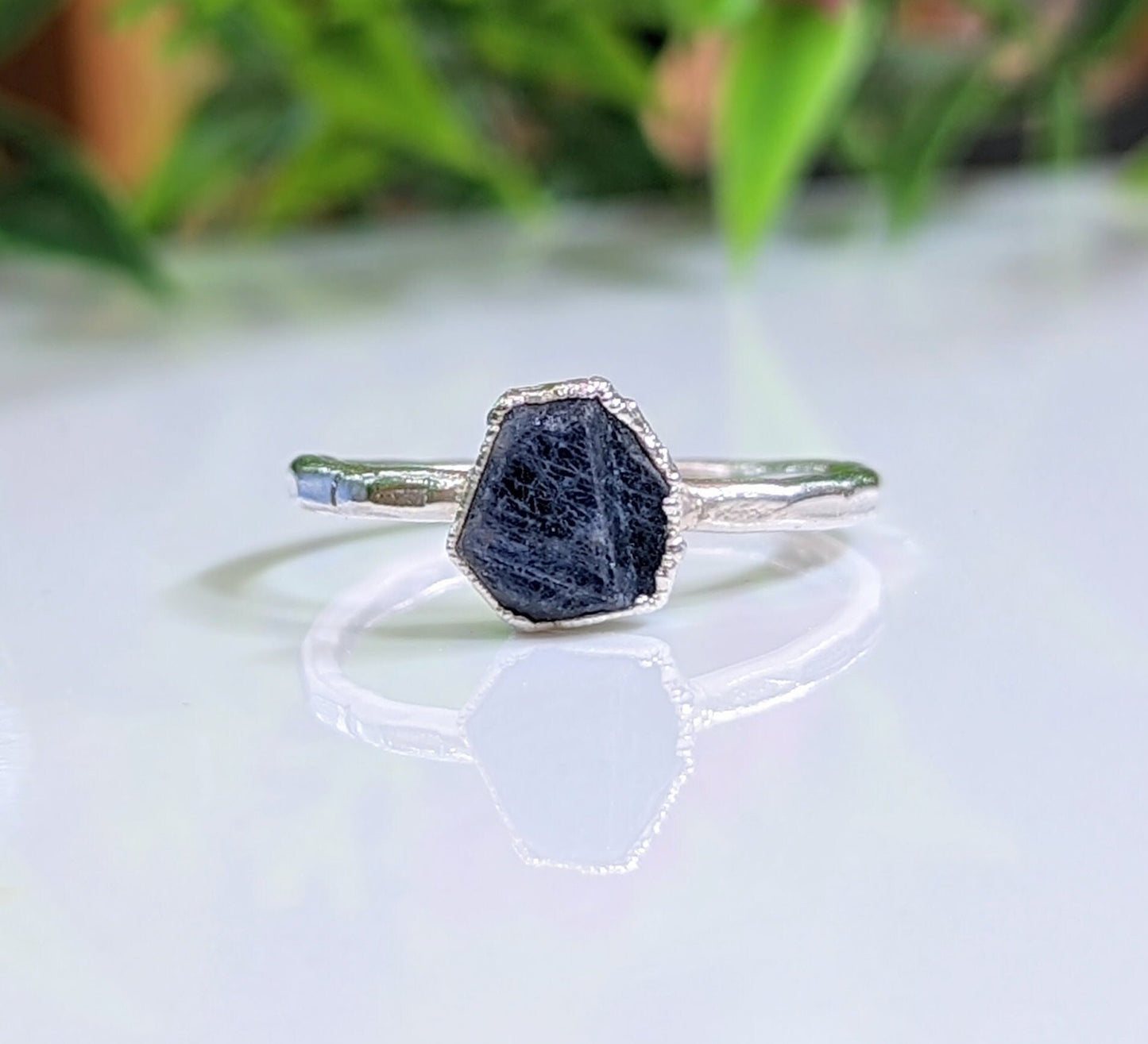 Handcrafted raw sapphire ring on silver band, perfect for nature lovers and September birthdays.