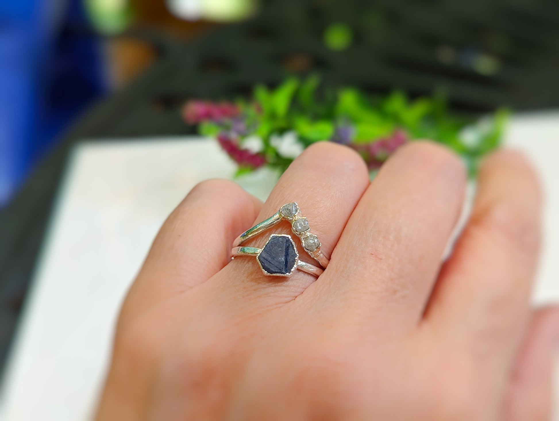 Unique raw sapphire and diamond chevron ring set on a hand, showcasing handcrafted sterling silver bands.