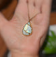 Rainbow Moonstone Kintsugi necklace on a hand, featuring electroformed design and gold plating.